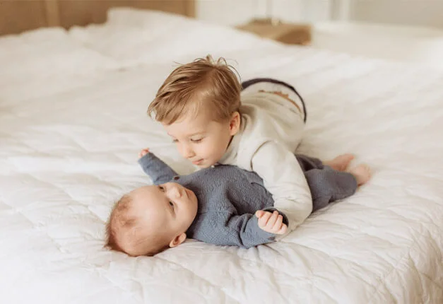 Toddler and baby in the bed