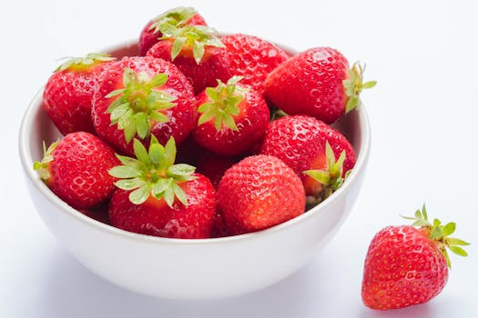 Vibrant and fresh strawberries in a white bowl, perfect for healthy eating or fresh produce visuals.