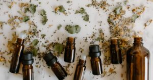 Flat lay of brown glass bottles and dried herbs, perfect for aromatherapy themes.